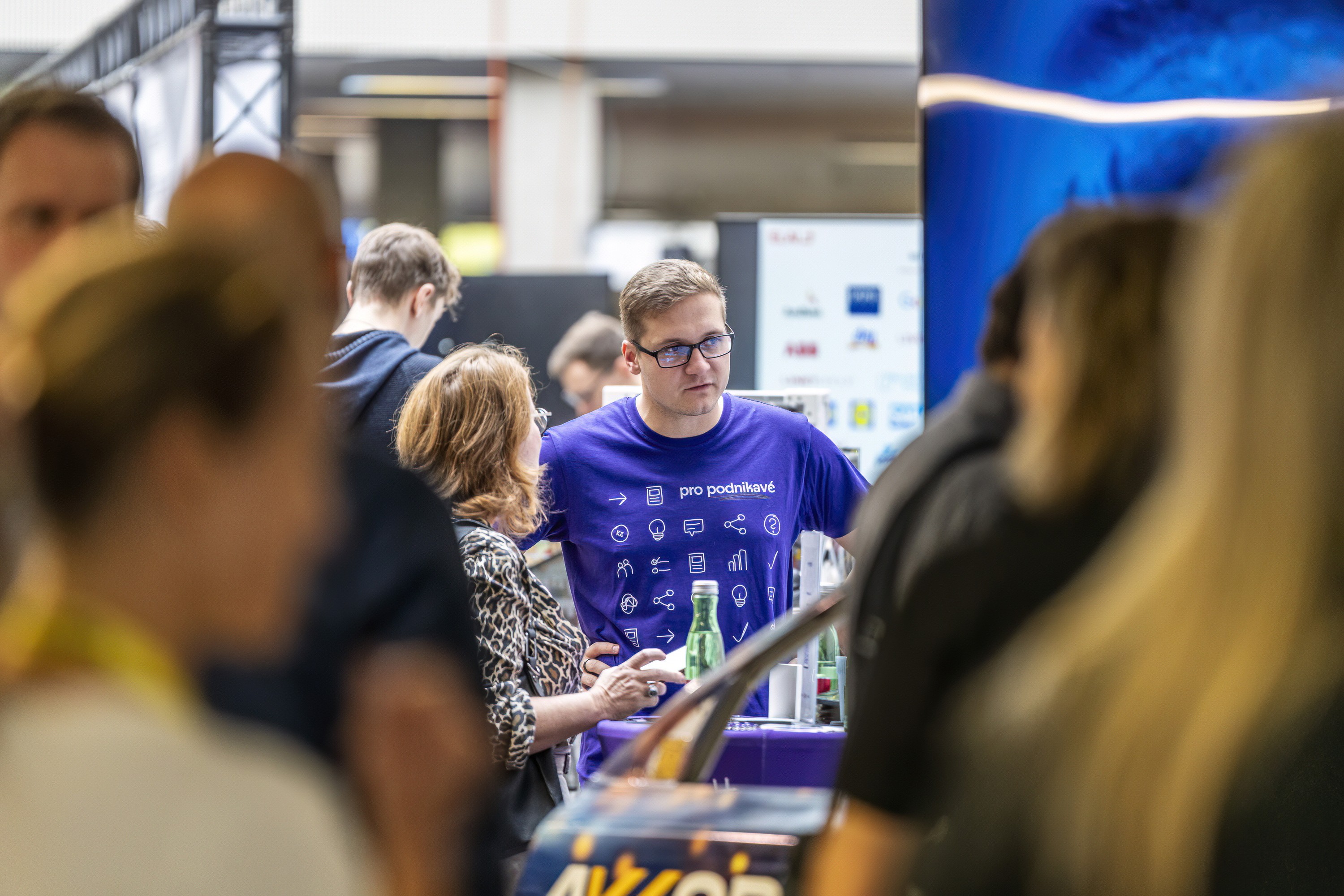 An exhibitor in conversation with a visitor at a company stand