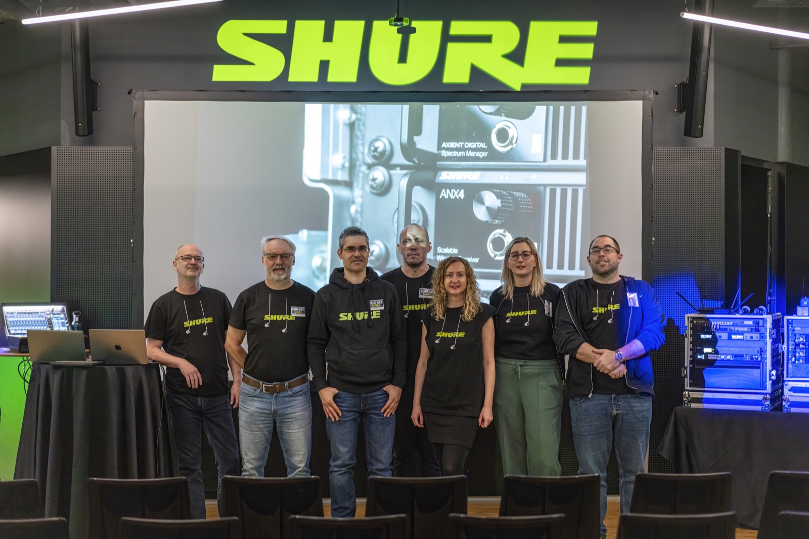 A company team photo with audio equipment on display