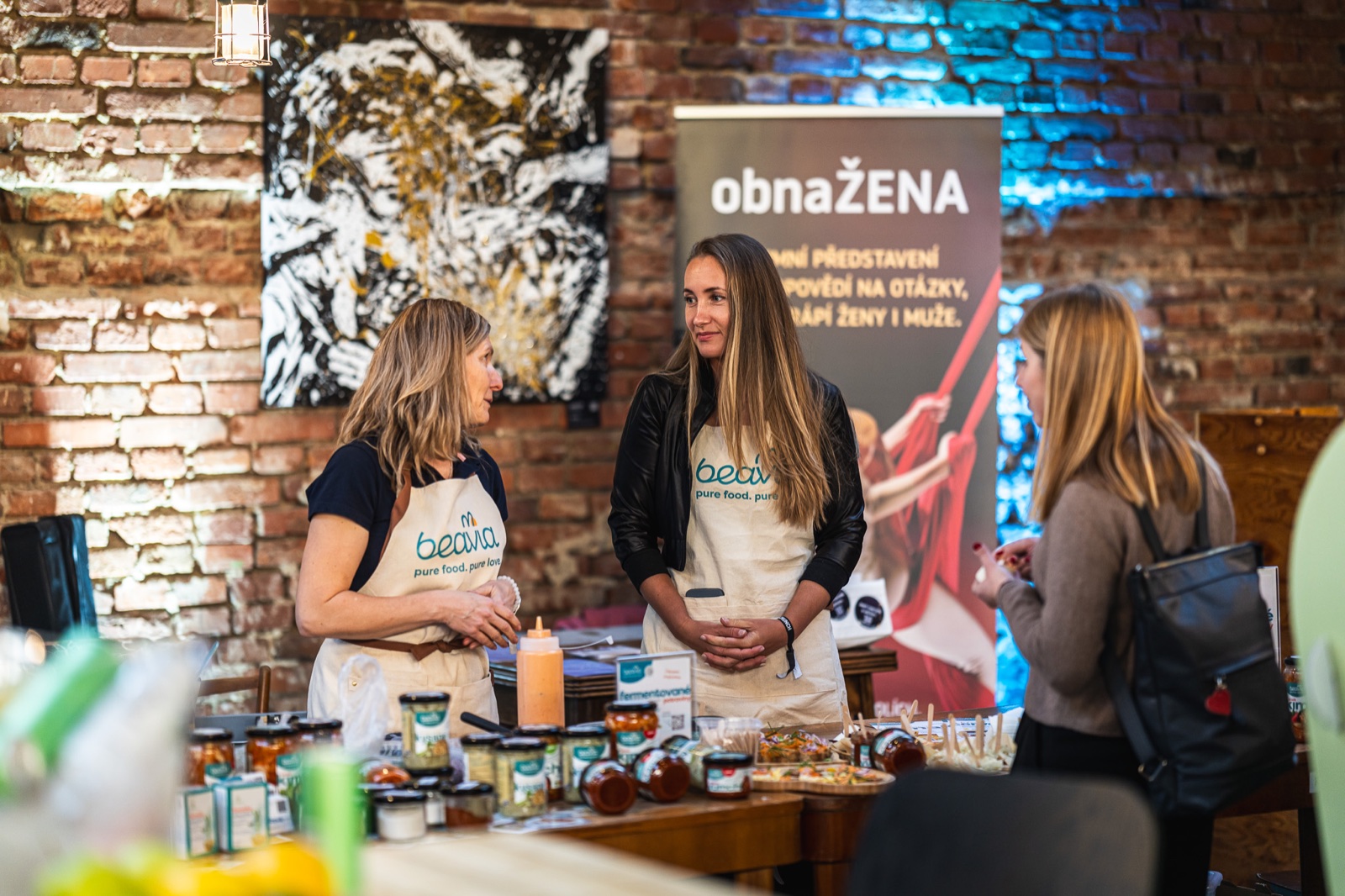 A brand representative talking with a visitor beside the products on display